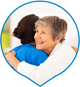 Elderly woman hugging home care assistant